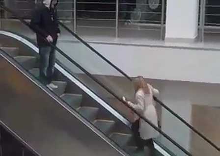 Блондинка йде по ескалатору