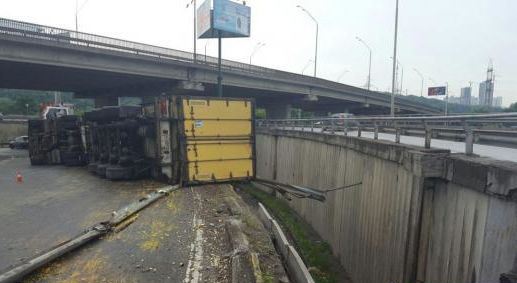 Фура перевернулась и свисает с моста в Киеве